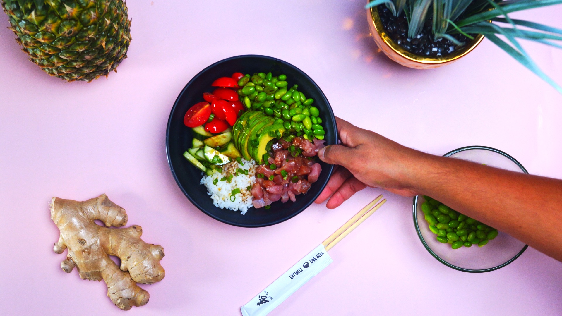 A poke bowl on a pink table