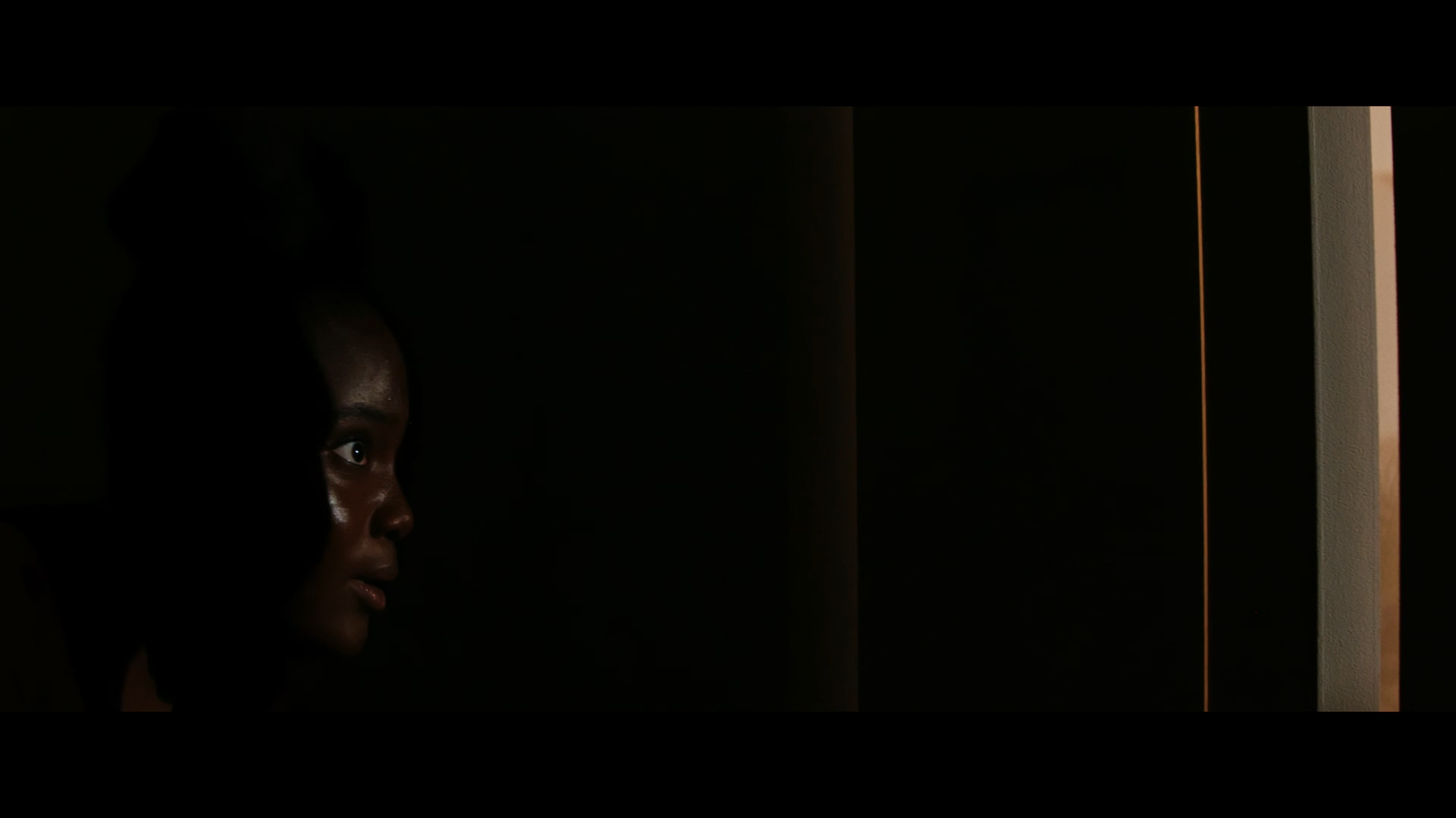 A woman in profile beside a doorway