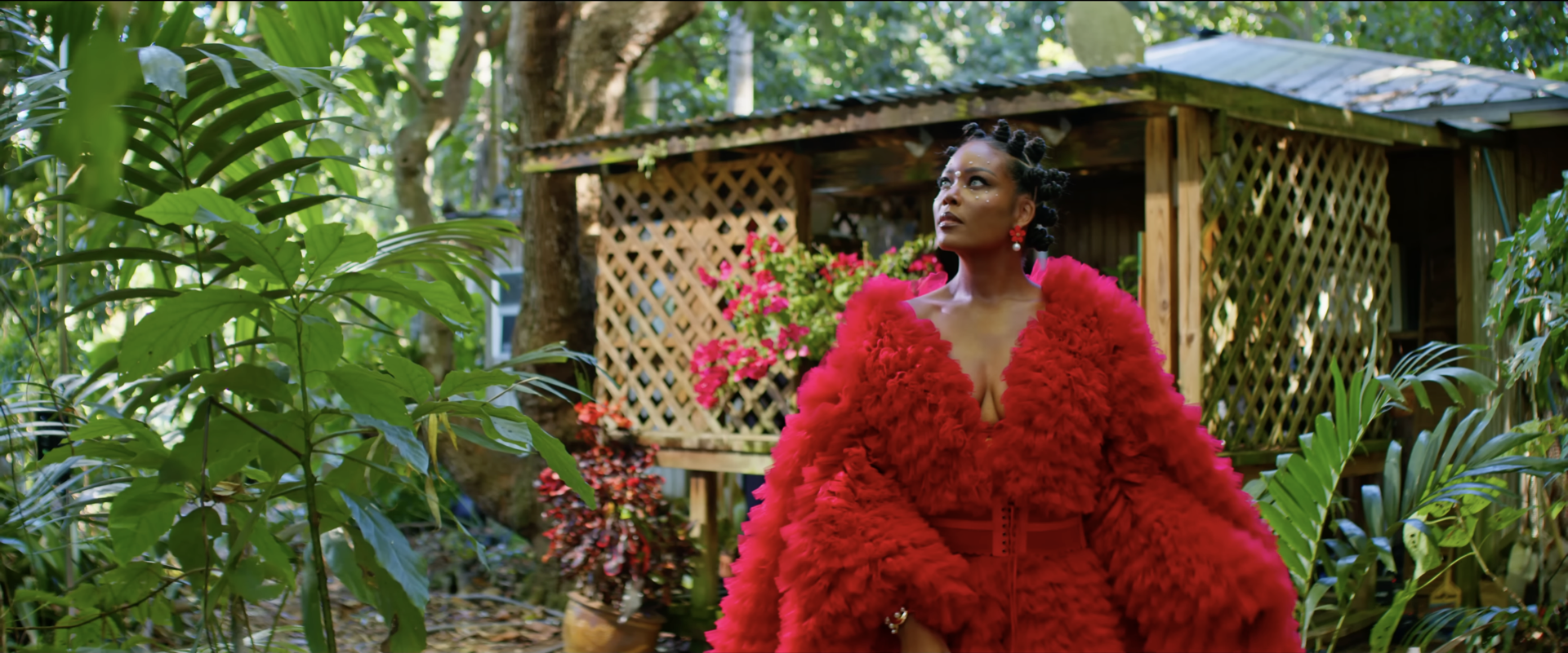 A woman in a red gown in a garden