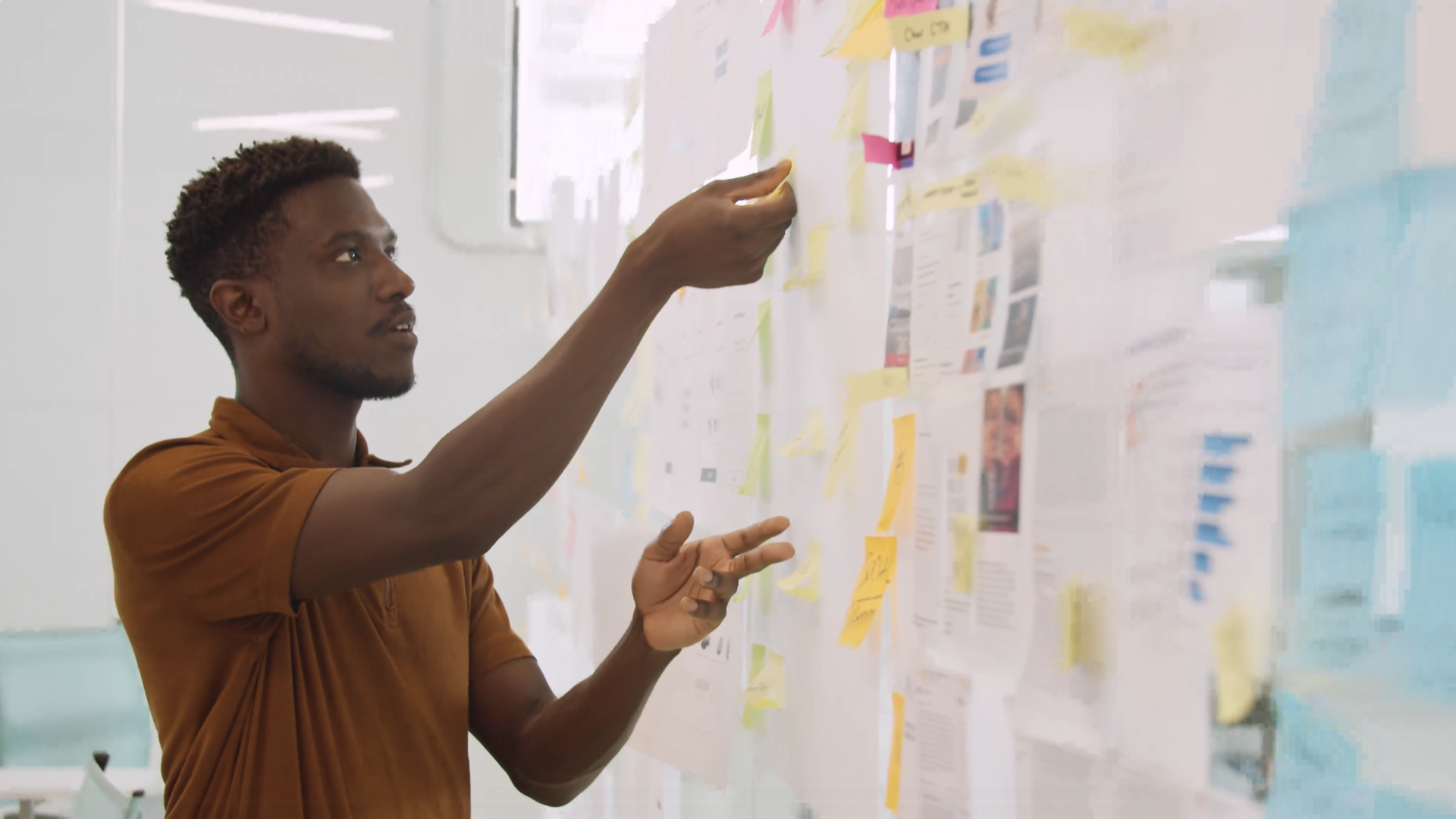 A man arranging notes on a wall