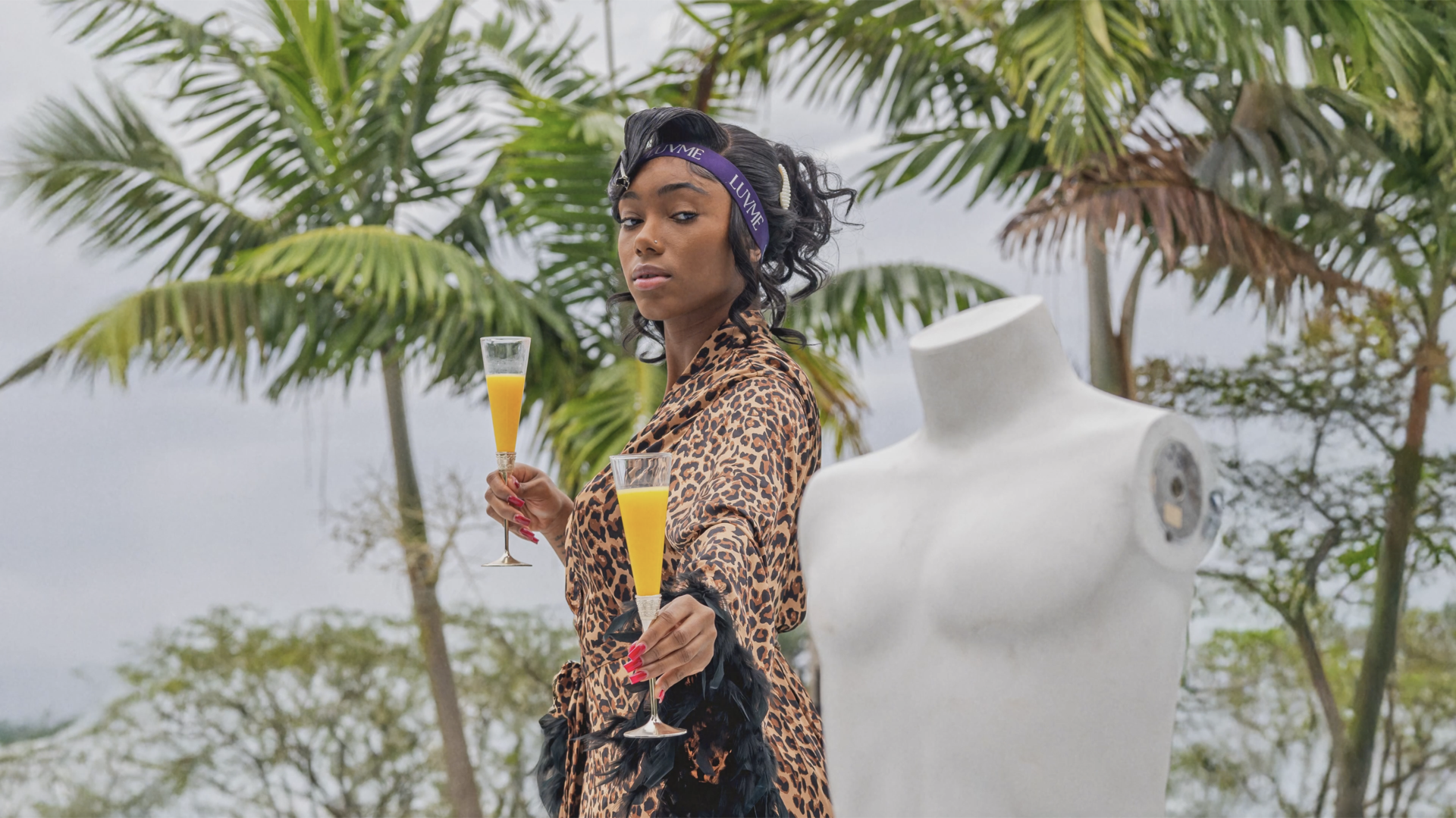 A woman holding drinks among palm trees