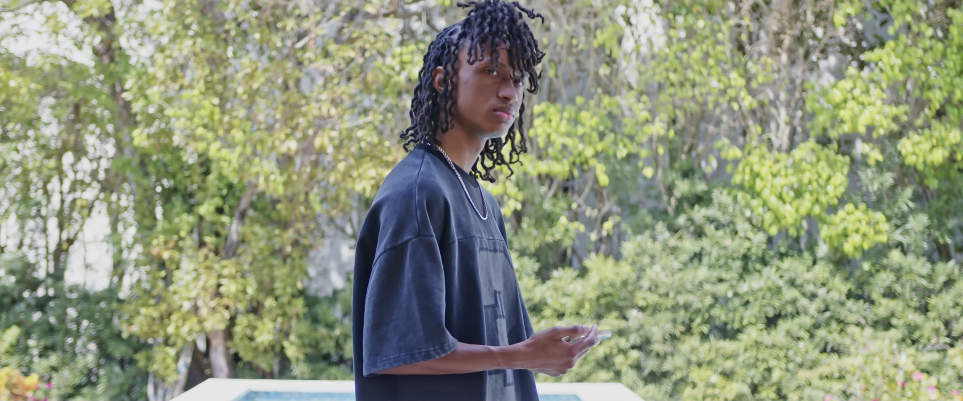 A young man standing by a pool